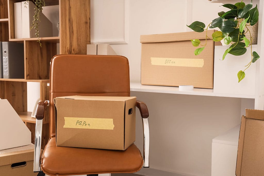 Cardboard moingboxes labbeled in and sitting in an office