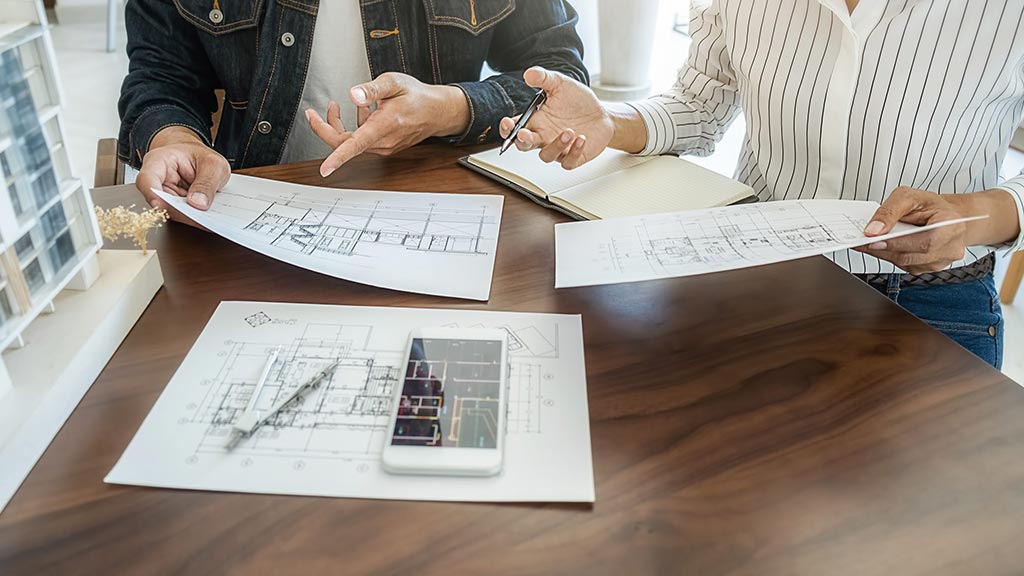 Two people working on a blueprint