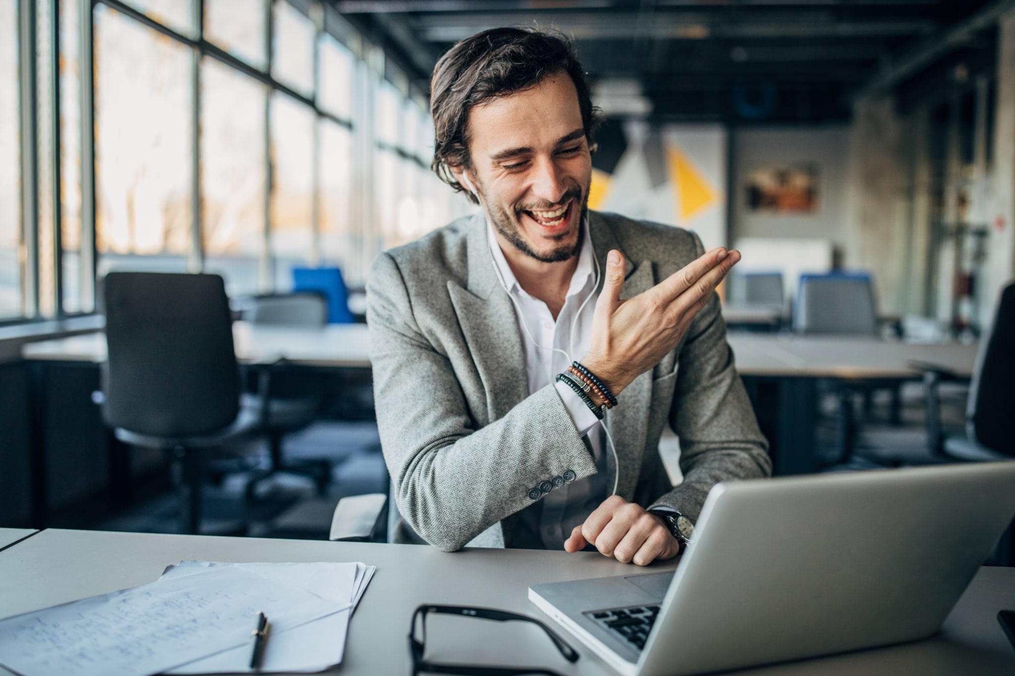 A man in an open office working on a conference call